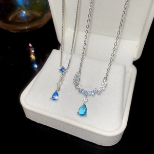 Detail of silver chain with light blue water-drop gemstone and sparkling cubic zirconia