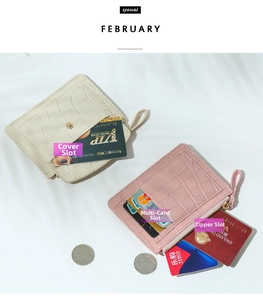 Detail of slim faux leather card holder with crocodile pattern and zipper pocket