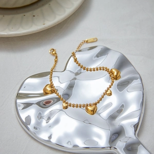 Luxurious 18k gold plated stainless steel heart charm bracelet on a silver tray