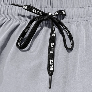 Detail shot of grey quick-dry fabric featuring a black flat drawstring with BUTZ lettering