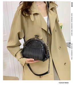 Details einer schwarzen Abendtasche mit Nieten und eleganten Fransen-Quasten