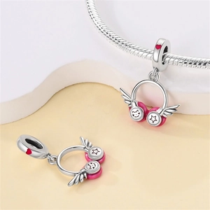 Macro shot of silver and pink headphone charm with red heart detail on snake chain