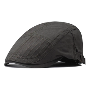 Detail of dark grey retro newsboy hat featuring decorative diamond stitching and metal buckle