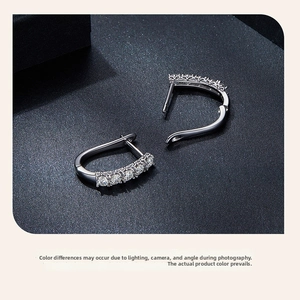 Macro view of U-shaped 925 silver hoop earrings with five sparkling moissanite stones