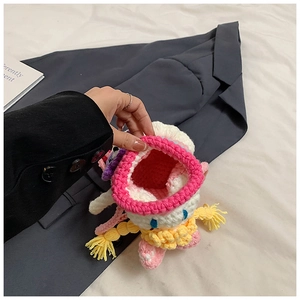 Detail of pink handmade knitted cartoon coin purse showing interior storage and yarn texture