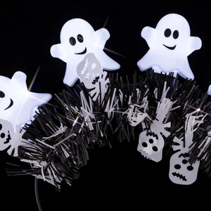 Detail of glowing white ghosts and black foil tinsel on a Halloween headband