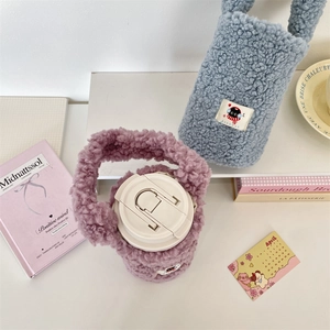Detail of plush lamb wool bottle covers in lilac and blue with cute cat patches