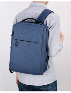 Blue minimalist business backpack with side USB charging port and zipper pockets