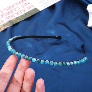 Detailed view of handmade 6mm blue marble crystal beads on a thin black metal headband