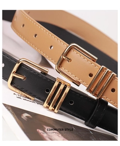 Detail of slim black and camel PU leather belts with elegant golden square metal buckles