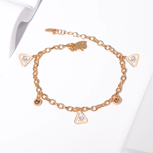 Detailed close-up of golden chain bracelet featuring three triangular cubic zirconia charms