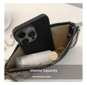 Detail view of snakeskin envelope bag interior showing capacity for phone and cosmetics