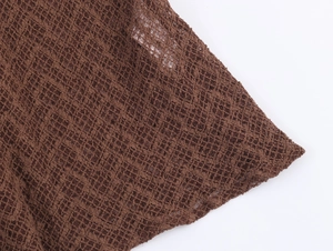 Close-up of brown lace mesh fabric showing detailed hollow knit texture and yarn patterns
