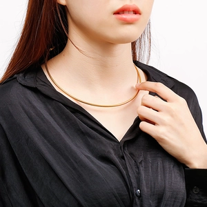 Close-up of golden stainless steel snake bone choker necklace on a model's neck