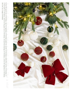 Festive red velvet bows and colorful Christmas tree ornaments on white satin fabric