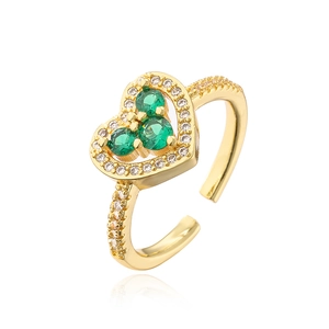 Detail of gold open ring featuring a heart frame with green zircons and white crystals