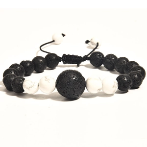 Close-up of black lava and white marble beaded bracelets with adjustable braided cords