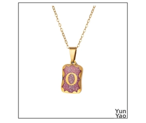 Detail of gold-plated rectangle pendant with pink glitter and letter O charm