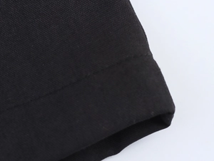 Macro shot of black twill fabric stitching on elegant two-piece women suit trousers