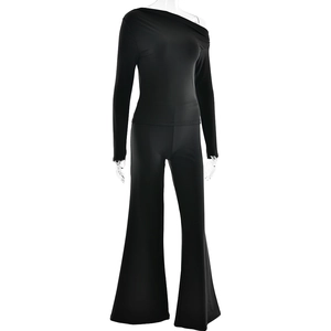 Detail view of black off-shoulder long sleeve top and flared trousers on model