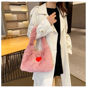 Close-up of pink plush handbag featuring a soft texture and a vibrant red heart decor
