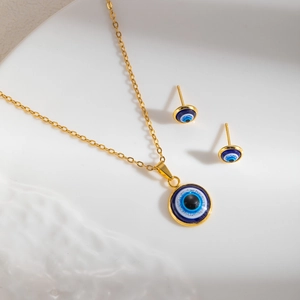Elegant gold Evil Eye jewelry set featuring a delicate necklace and round stud earrings