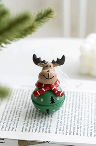 Macro view of a Christmas reindeer bell ornament with green polka dots on an open book