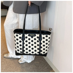 Polka dot tote bag with leather trim on model showing commuter fashion style