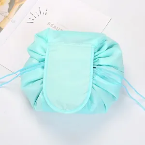 Flat lay of a mint green drawstring makeup bag with flap closure on a white background