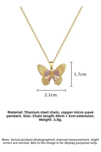 Detailed macro shot of a gold titanium steel butterfly necklace with pink rhinestones