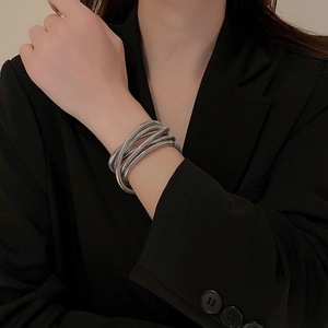 Macro detail of vintage silver-tone triple-layer elastic bracelet on model wearing black