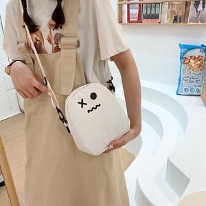 Sac à bandoulière blanc mignon avec visage minimaliste porté par une femme modèle