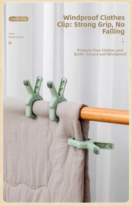 Close-up of windproof quilt clip with soft grey non-slip pads on a wooden clothes rail