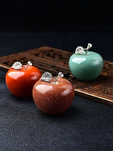 Detailed shot of stone apple figurines with sparkling diamond-set metal leaves and stems