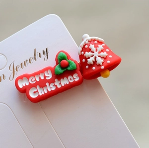 Close-up of Christmas bell hair clip with Merry Christmas text on display card