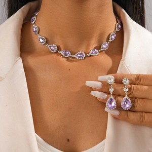 Détail d'un ensemble élégant avec collier et boucles d'oreilles goutte mauve