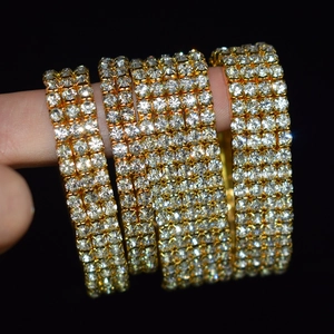 Macro detail of wide multi-row sparkling crystal stretch bracelet in gold finish
