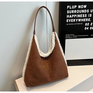 Close-up of brown suede tote bag with white plush trim and leather shoulder strap detail