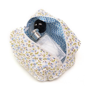 Floral makeup bag with blue flowers, white fabric, large capacity, and zipper closure