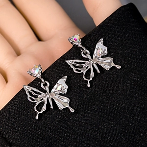 Macro shot of butterfly stud earring with shimmering crystals on black fabric