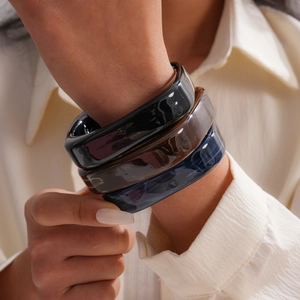 Detail showing marbled texture of square resin bangles in black, amber, and blue