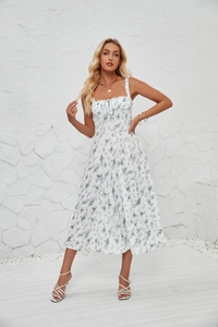 Detail of white floral sundress with green print showing drawstring neck and thin straps