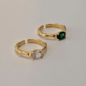 Irregular gold rings set with green and white zircon stones in an adjustable open design