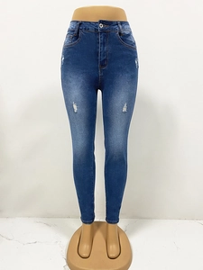 Détail du jean skinny bleu foncé avec déchirures stylées et finitions en denim délavé premium