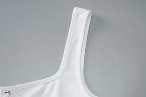 Close-up of white ribbed knit fabric texture and strap detail on a slim-fit vest