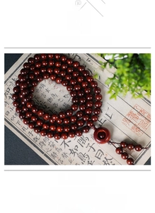 Macro shot of 108 sandalwood prayer beads with silk tassels and glossy wood texture