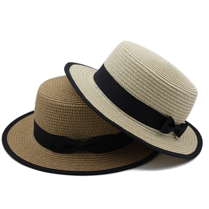 Straw boater hats with chic black ribbon bows and bound edges for summer beach vacations