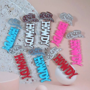 Flat lay of colorful acrylic HOWDY cowboy hat earrings with glitter and leopard patterns