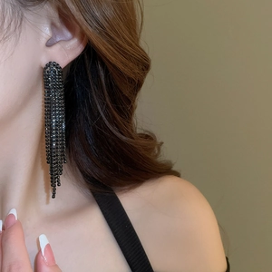 Close-up of elegant black rhinestone long tassel earrings hanging from ear lobe