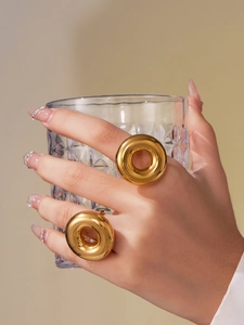 Close-up of dual hollow donut rings in 18k gold plated stainless steel on fingers